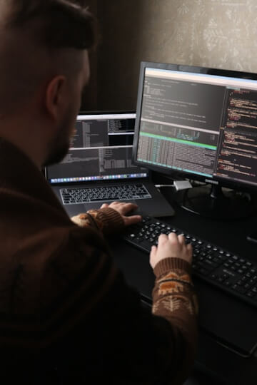 a man sitting in front of a computer on a desk